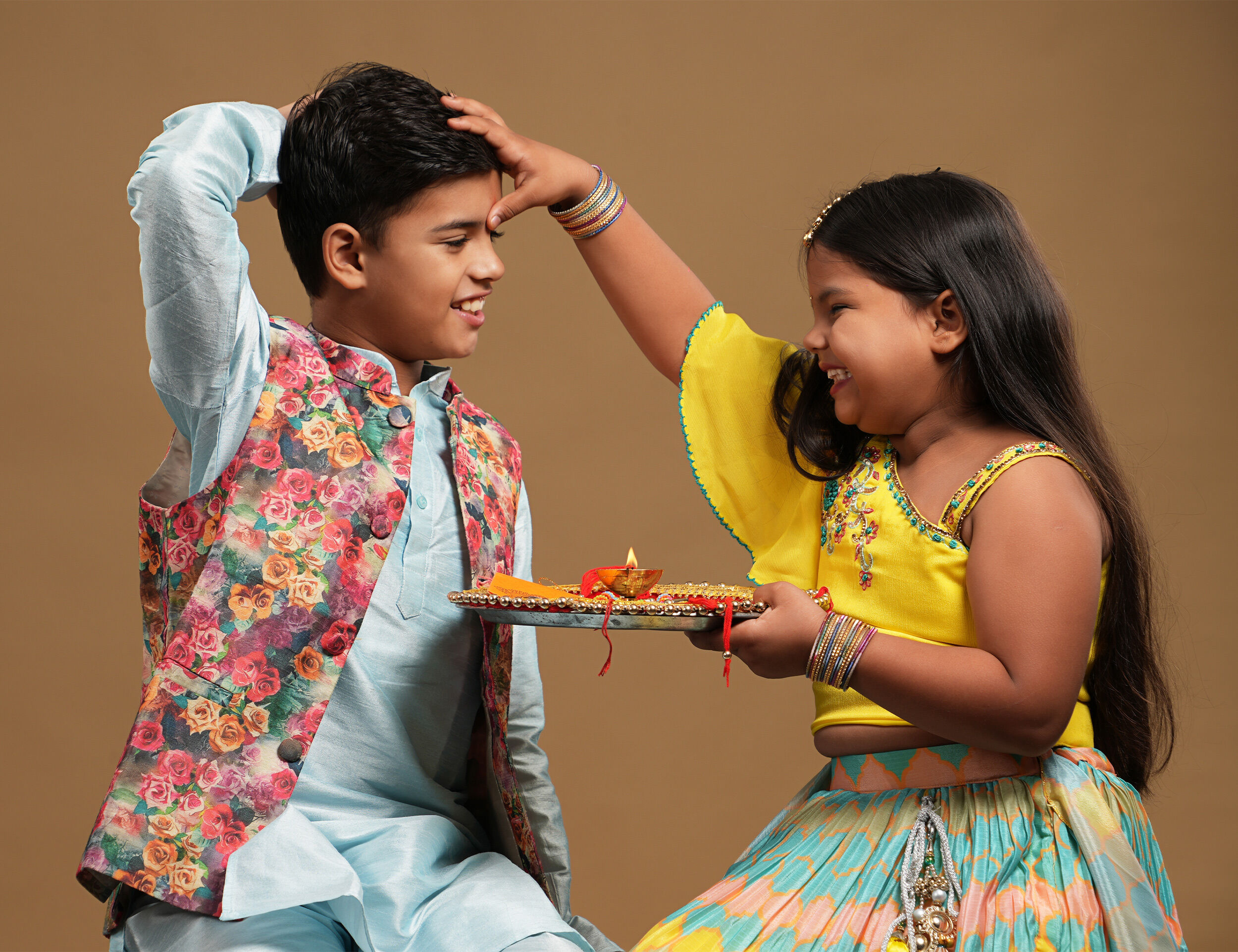 Sister applying tika on brothers forehead with smile 